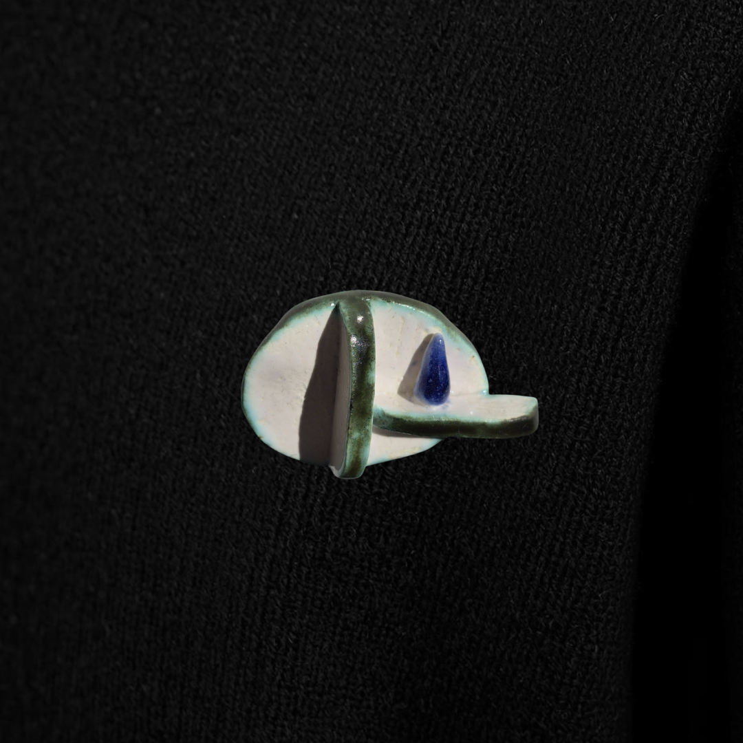 Small ceramic ring with a blue cone on a black background
