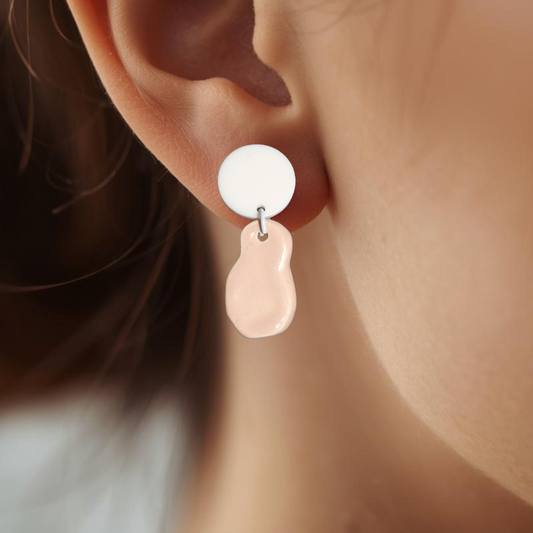 Close-up of an ear wearing a white and pink earring.