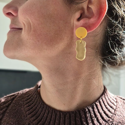 Woman wearing gold earrings with a blurred background