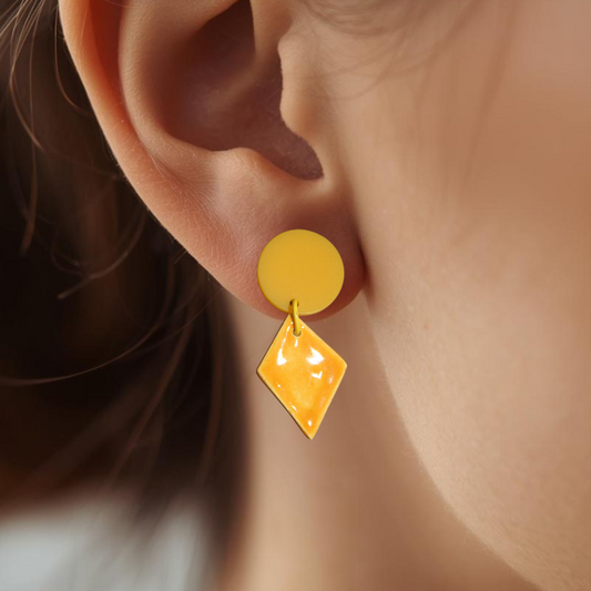 Close-up of a person wearing yellow earrings with a blurred background