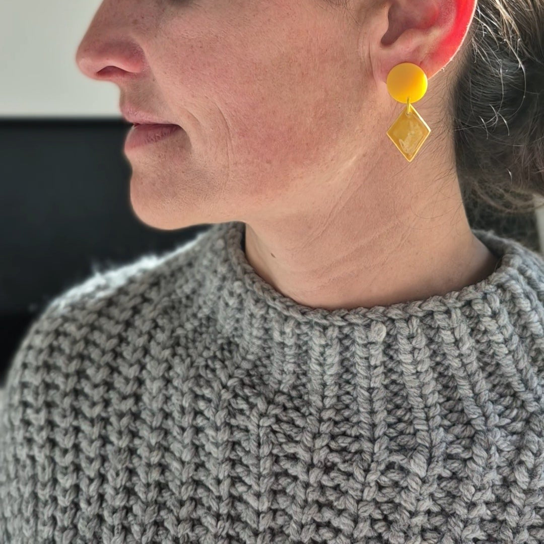 Woman wearing yellow earrings, side view