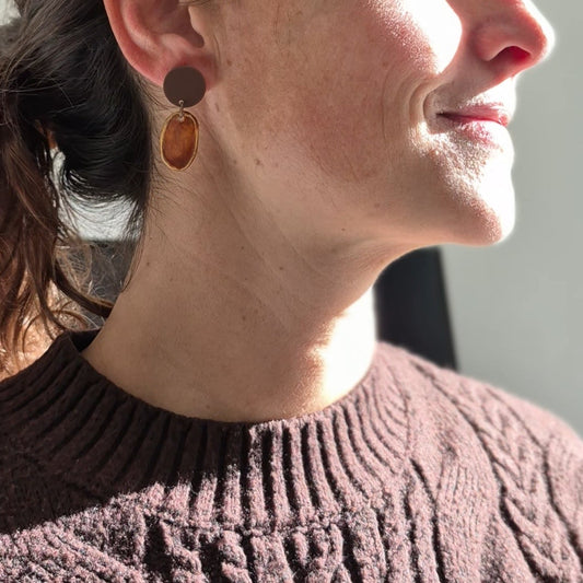 Woman wearing earrings with a neutral background
