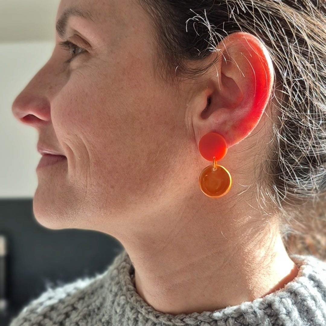 Woman wearing orange earrings, side view