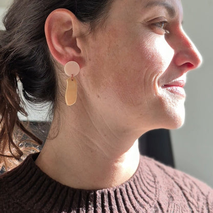 Woman wearing earrings with a neutral background