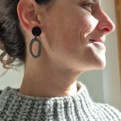 Woman wearing black earrings, close-up of face and neck.