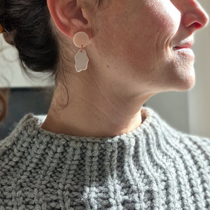 Woman wearing a pink ceramic earring with a blurred background