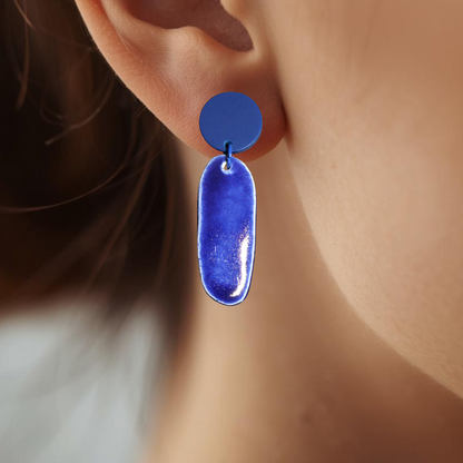 Blue earring worn by a person with a blurred background