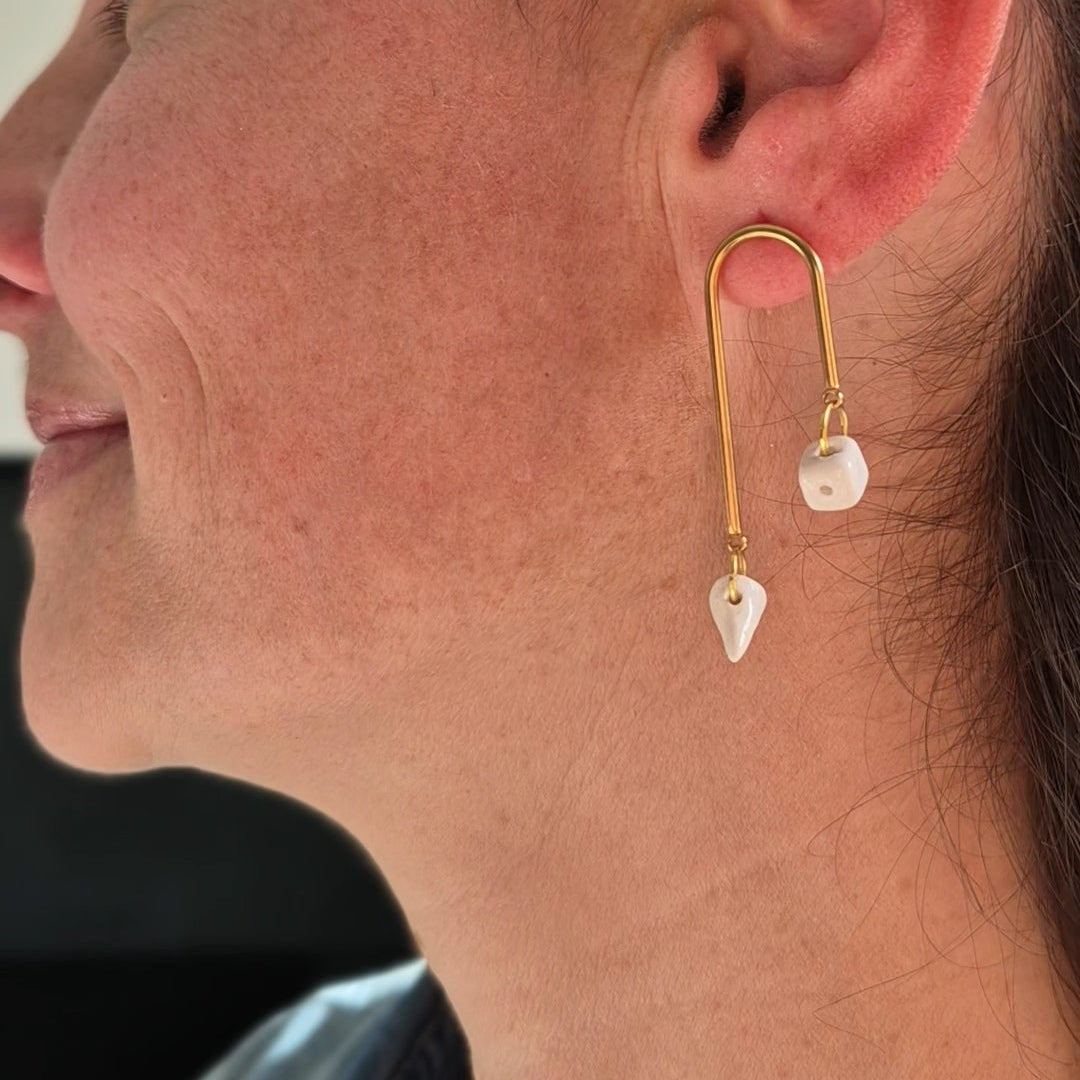 Close-up of a woman wearing gold earrings with a blurred background