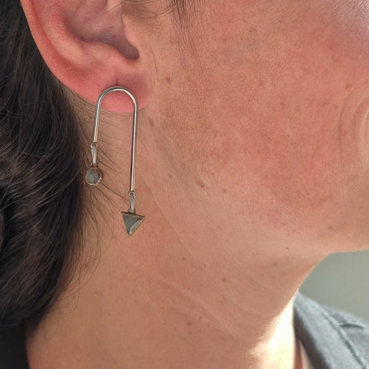 Close-up of a person wearing a unique earring.
