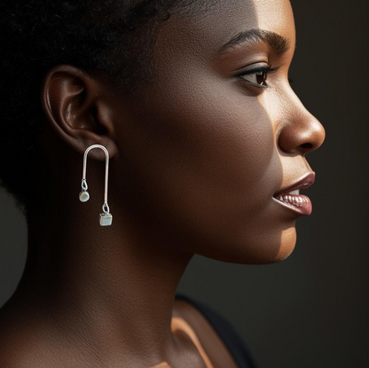 Profile of a woman wearing a unique earring against a dark background