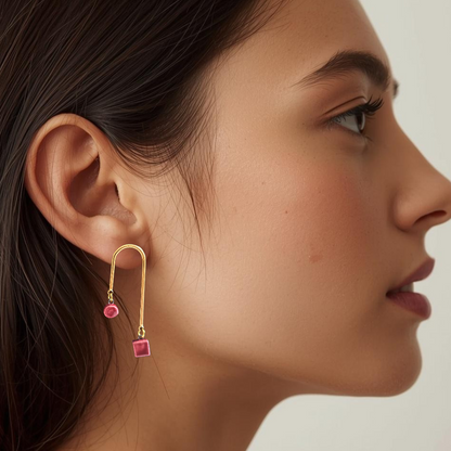 Close-up of an ear wearing a garnet ceramic earring with a blurred background