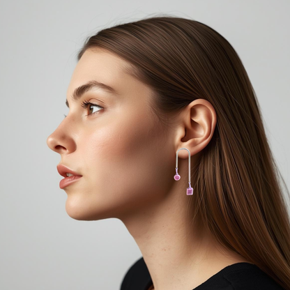 Woman wearing a lillac earrings with a grey background