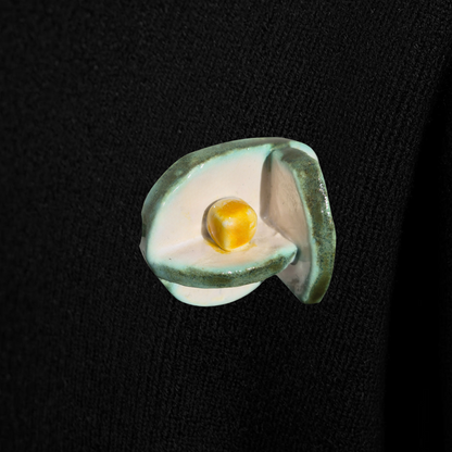 Ceramic pin with a yellow cube on a black background
